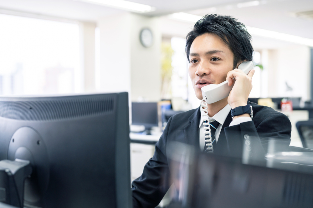 オフィスで電話する男性